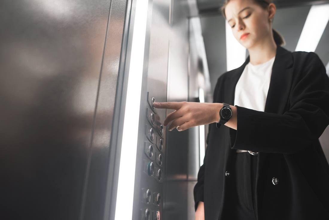 diligent-businesswoman-pressing-button-inside-elevator-with-watch-her-wrist_tn.jpg