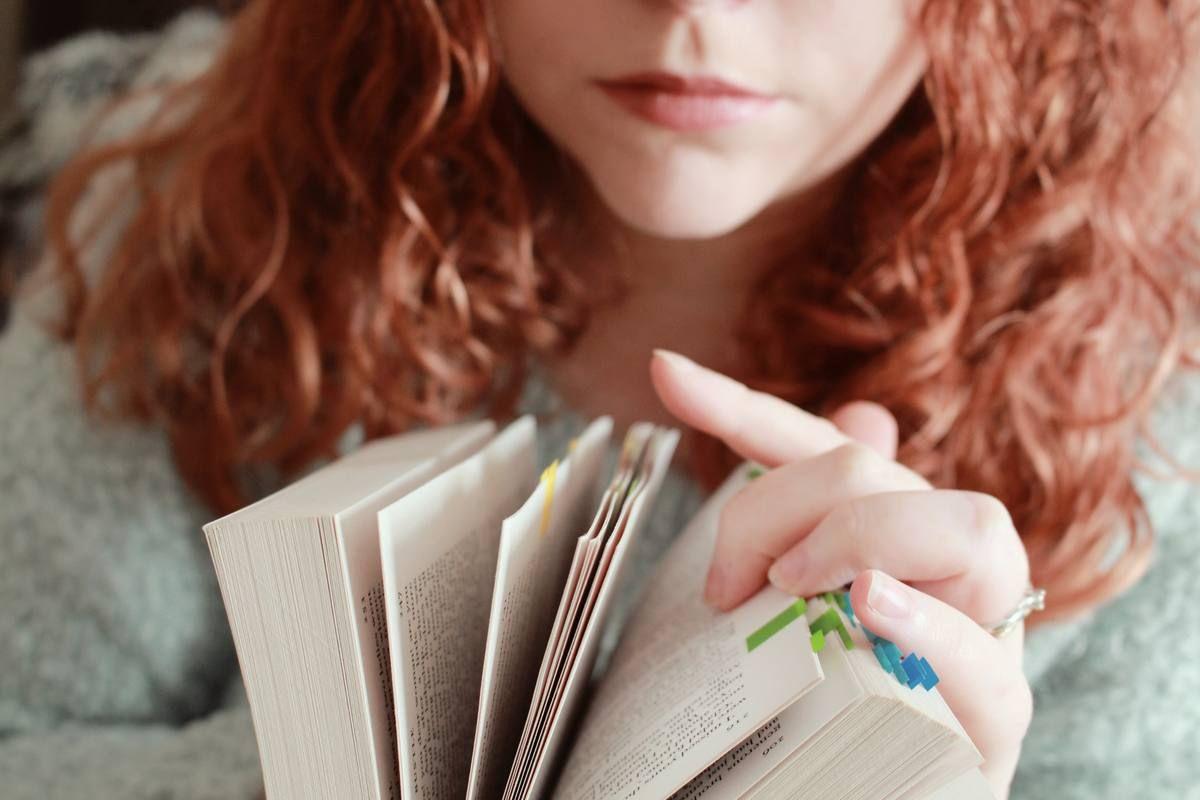 red-haired-female-with-serious-facial-expression-looking-through-book.jpg