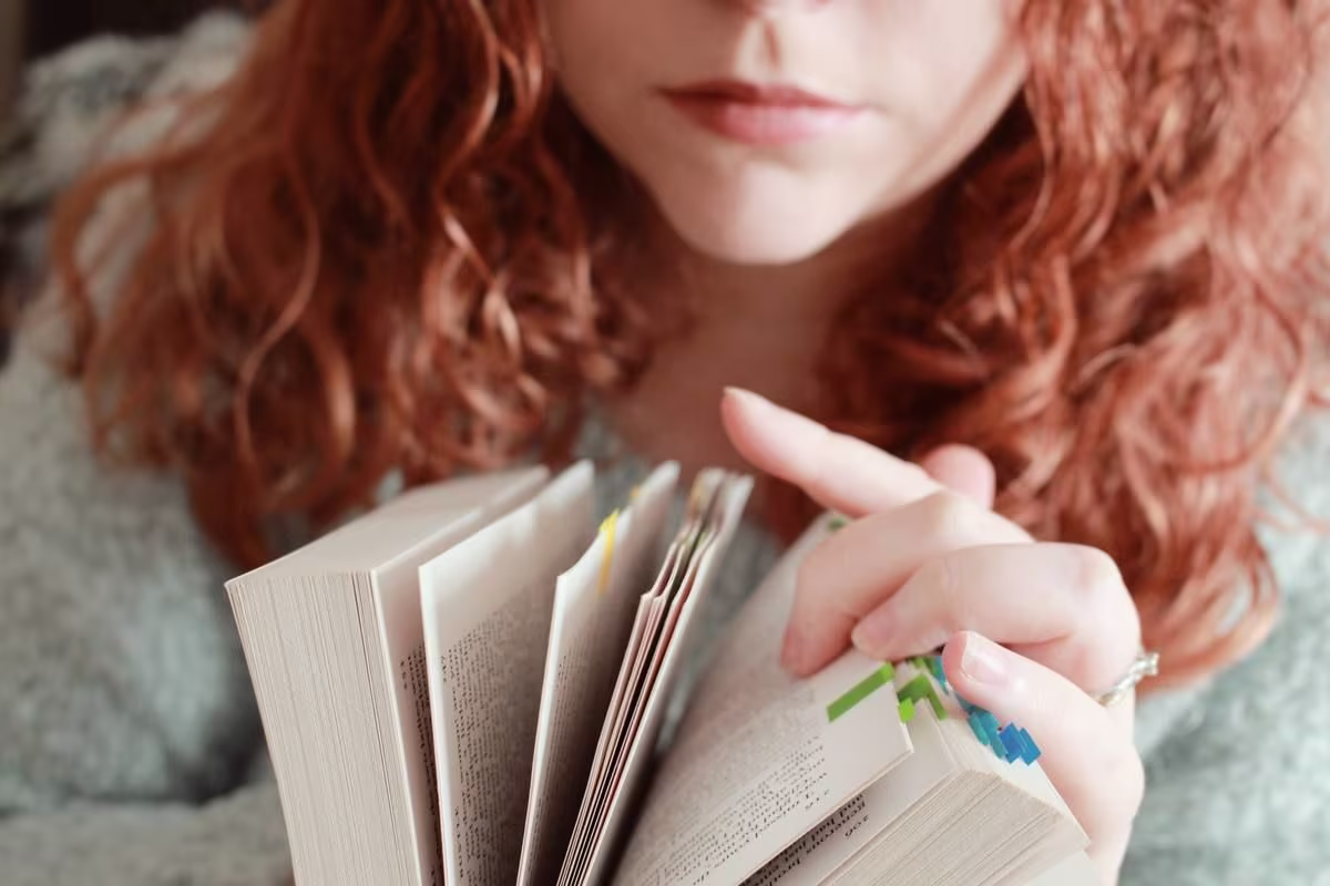 red-haired-female-with-serious-facial-expression-looking-through-book.jpg